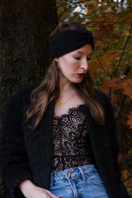 Clarissa, Gründerin von filartdoré, mit Libellenkette vor einem Baum im Herbst